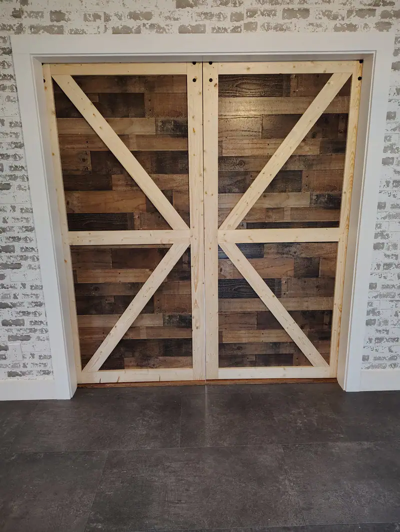 Rustic X-brace barn doors in a white brick opening