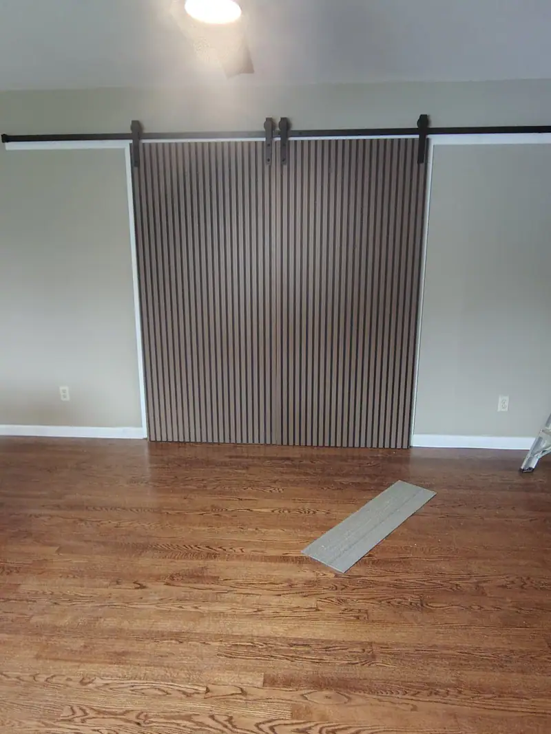 Slatted sliding barn door on a black track