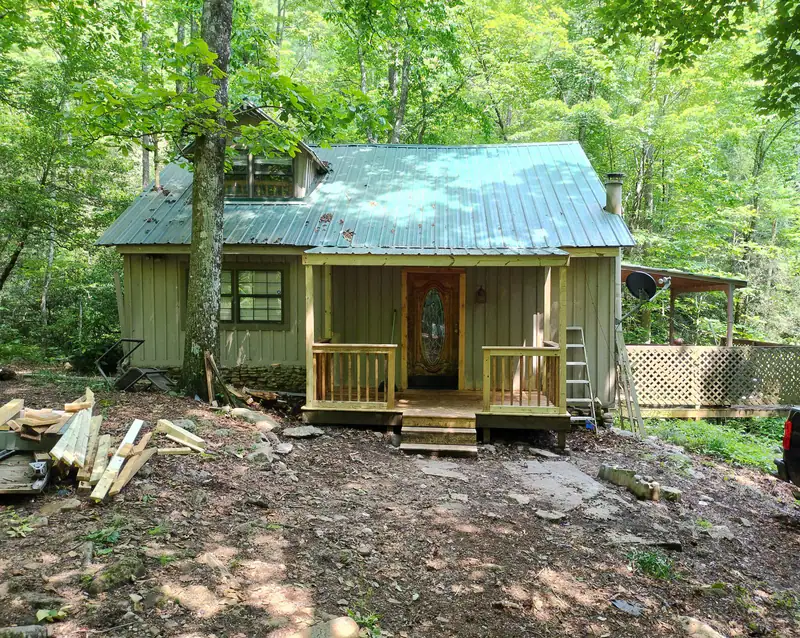 Cabin front porch with new wood railings and steps
