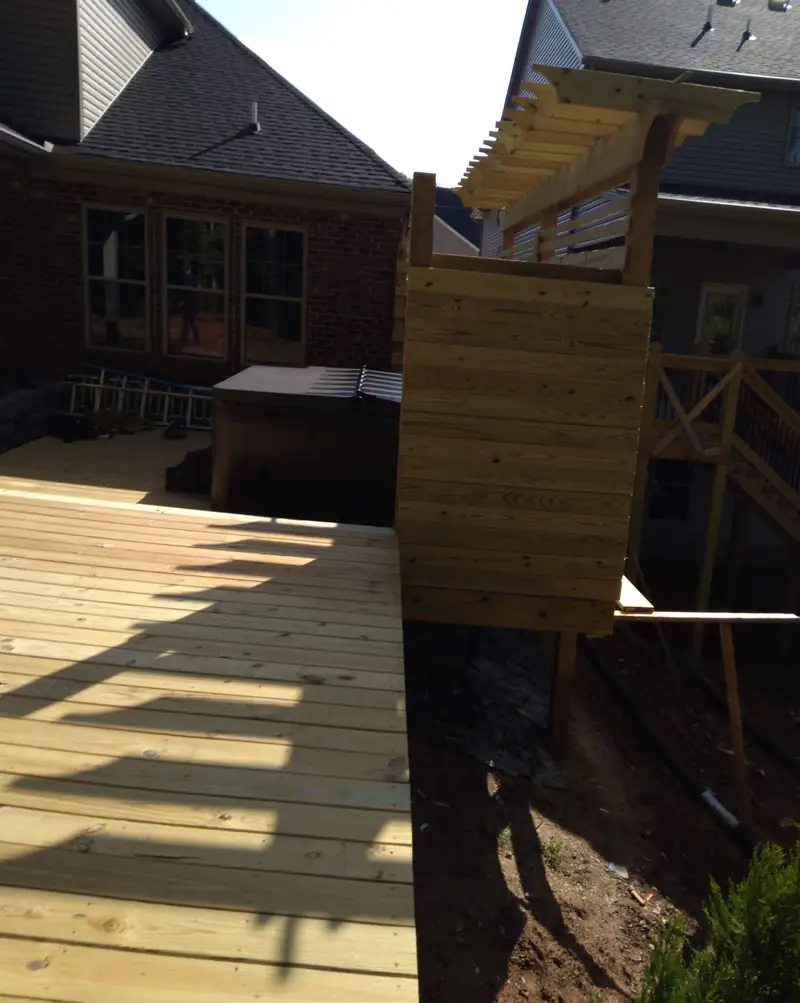 Fresh deck boards running to a pergola privacy screen