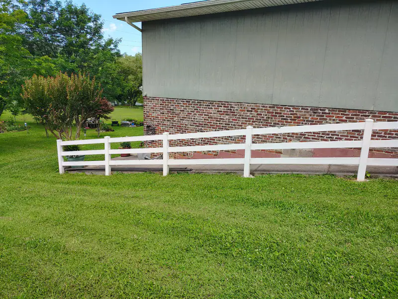 White rail fence and new stairs along the side of a house
