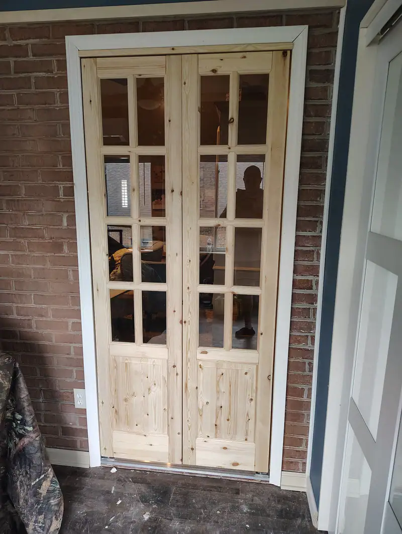 Pine French doors with divided glass, hung in a brick wall