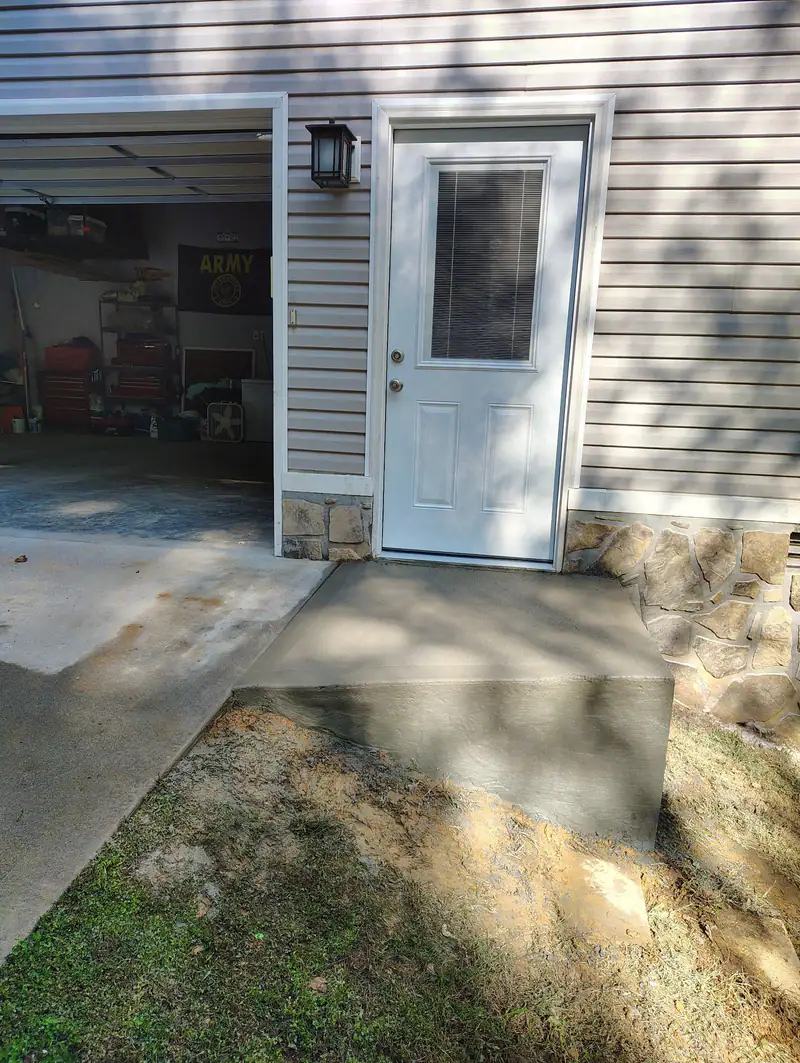Finished concrete pad at a side entry door