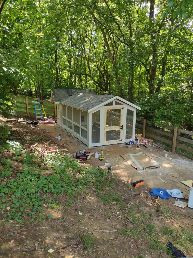 Finished playhouse with windows and a shingled roof in the woods