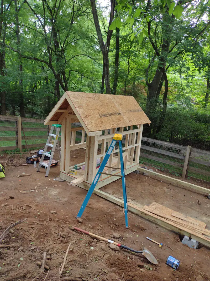 Kids’ playhouse being framed in a wooded backyard