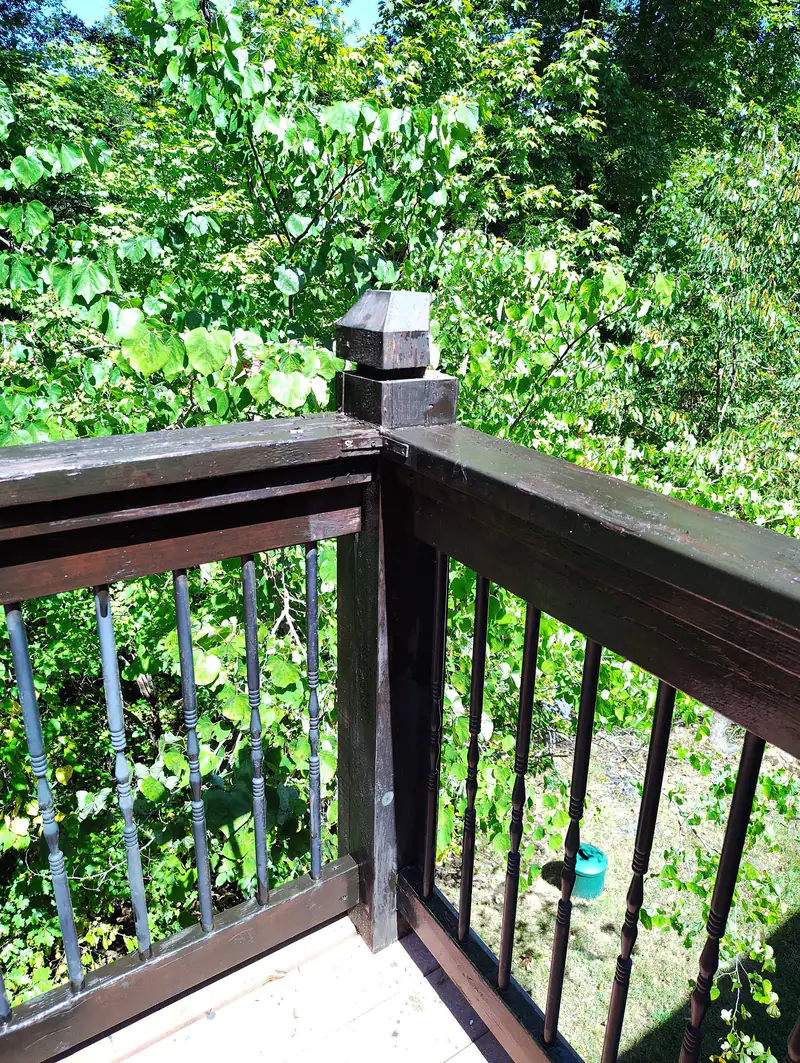 Stained deck railing and post cap, close up