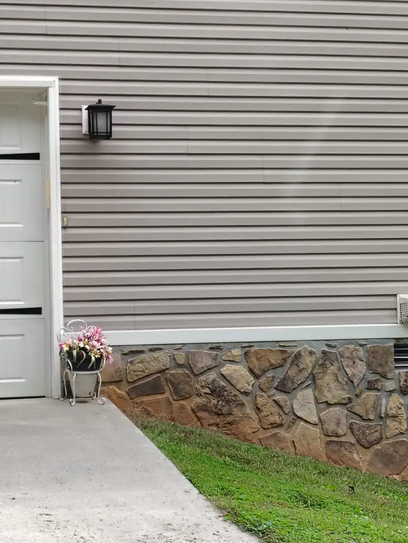 Concrete walk along a stone-skirted house